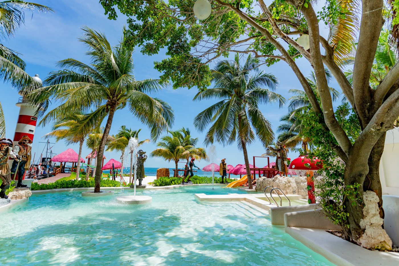 Camastros bajo palmeras en la playa en Hotel Grand Oasis Palm