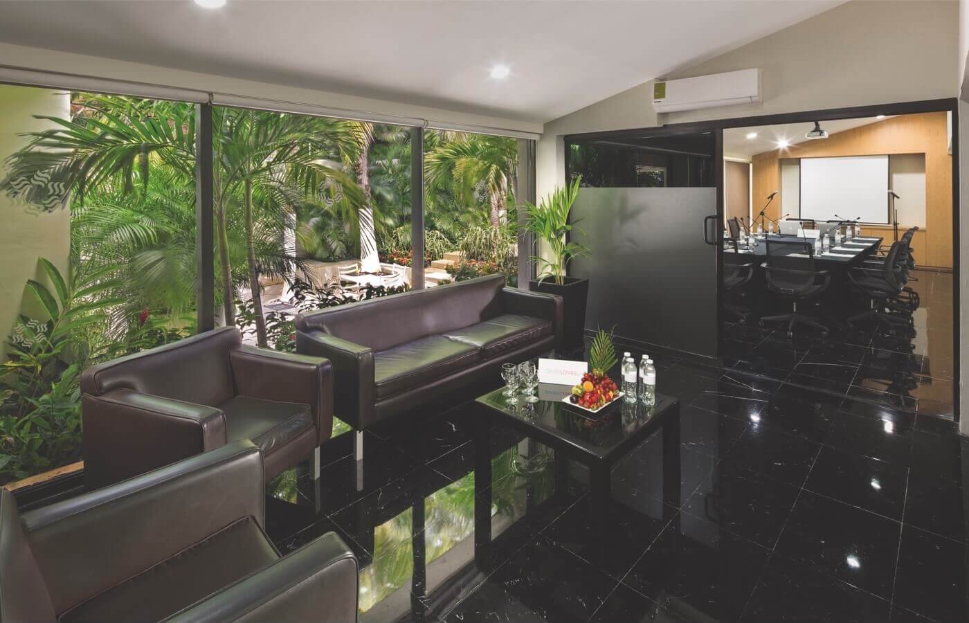 Sala para reuniones con sillas, mesas y escenario en Smart Cancun by Oasis