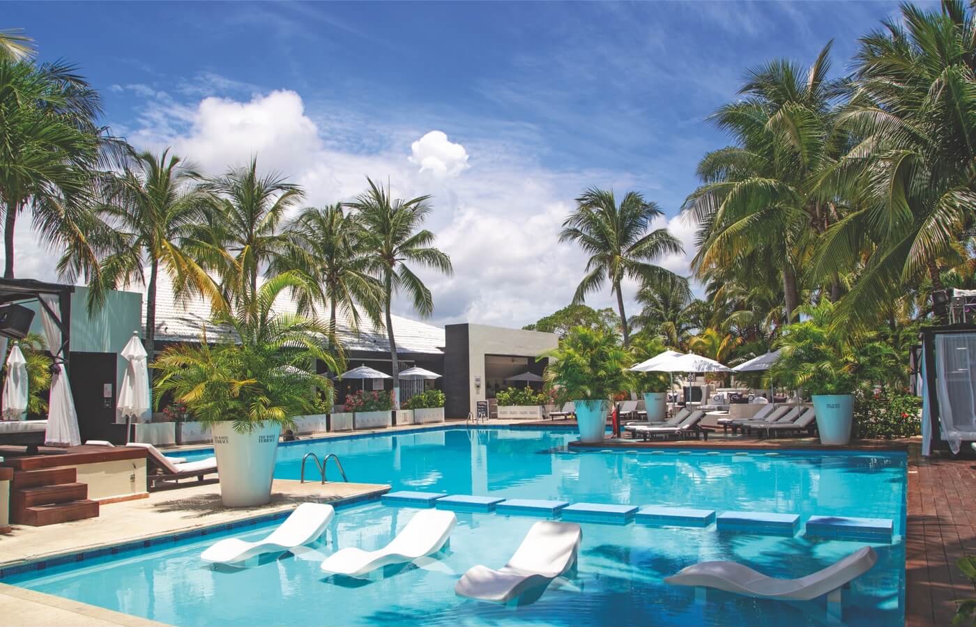 Alberca con camastros en el hotel Smart Cancun by Oasis